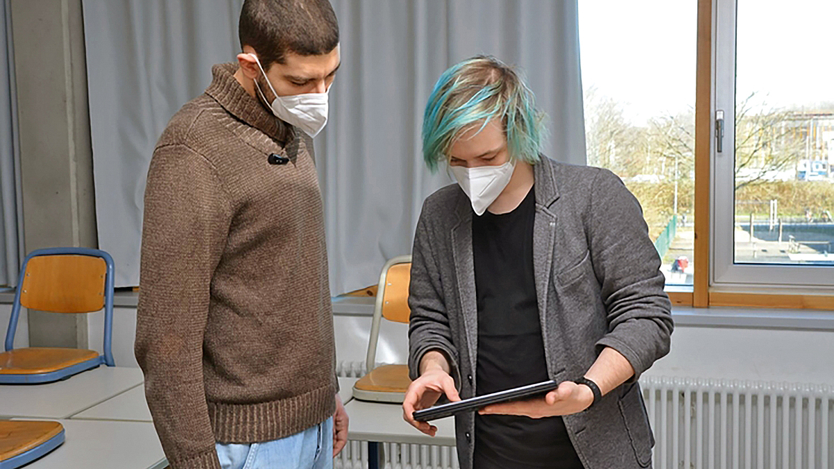 Zwei Studenten arbeiten an einem Tablet.