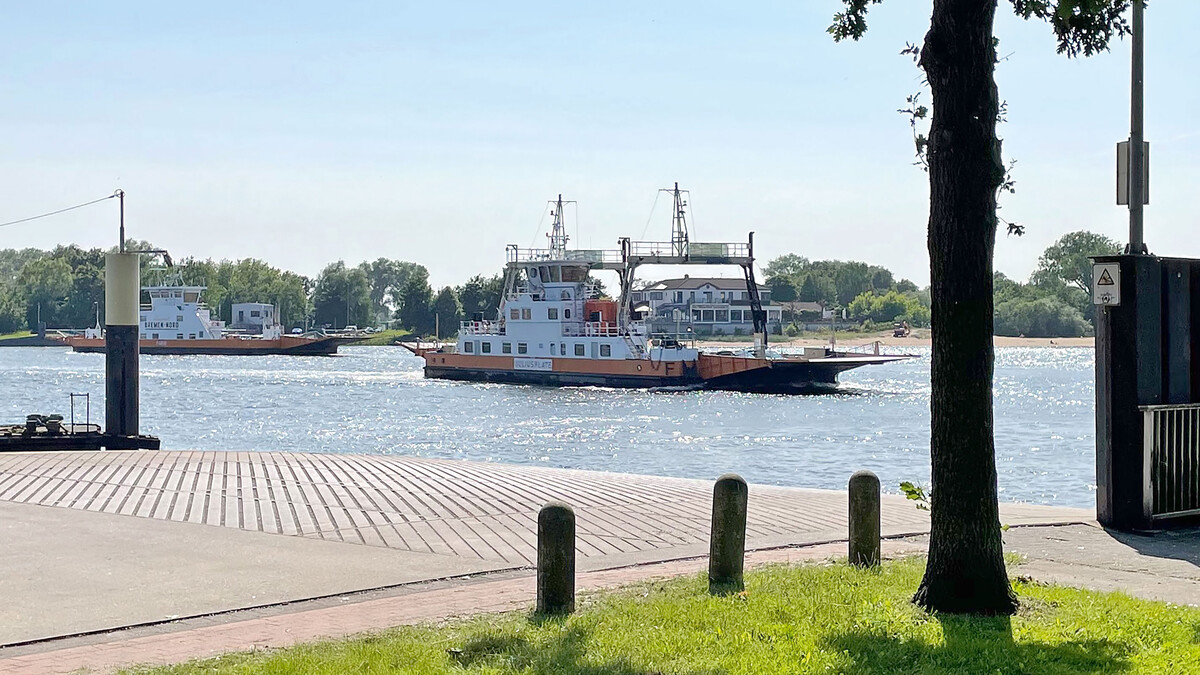 Zwei Fähren kreuzen auf einer Wasserstraße zwischen zwei Anlegestellen.