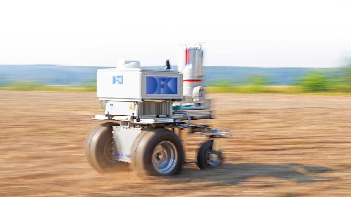 Ein Agrarroboter fährt auf einer Ackerfläche