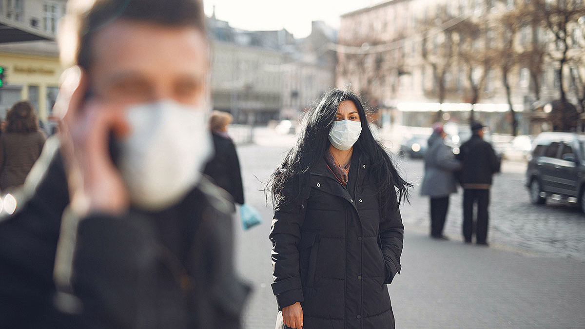 Menschen mit Mund- und Nasenschutz in der Stadt.