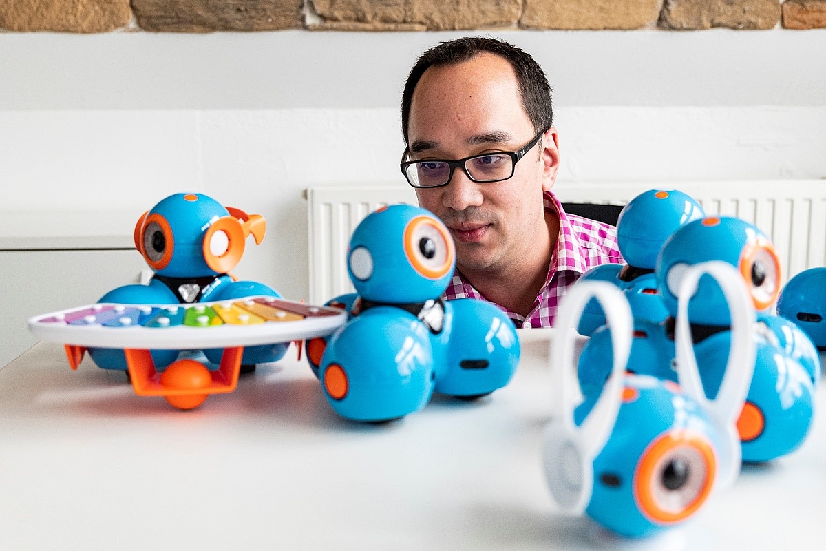 Auf einem Tisch stehen kleine Roboter, die aus bunten, kugelförmigen Bauteilen bestehen.