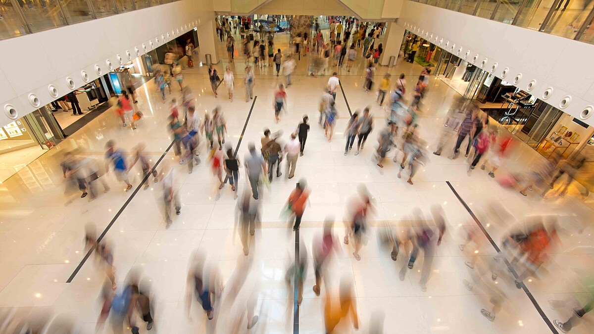 Kunden bewegen sich in der Passage eines Einkaufszentrums.