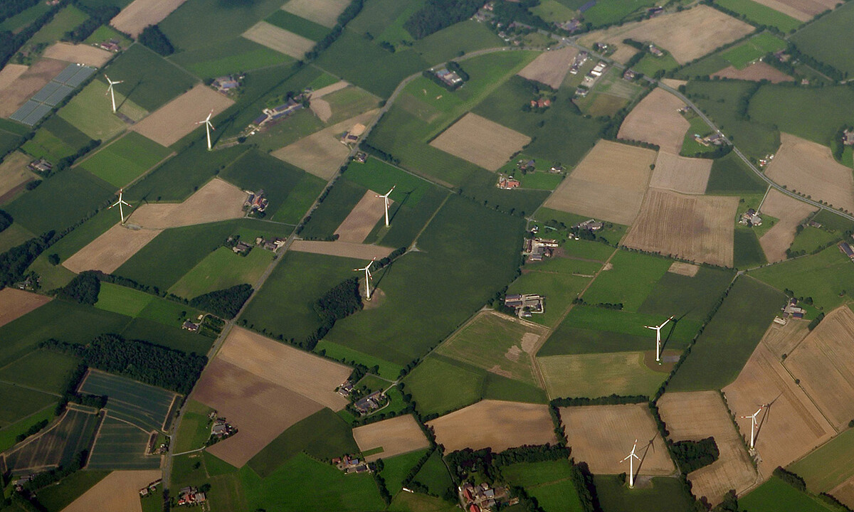 Windenergieanlagen zwischen Feldern auf einem Luftbild