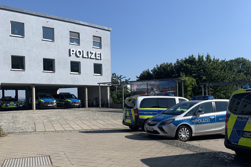 Polizeistation mit geparkten Polizeifahrzeugen davor